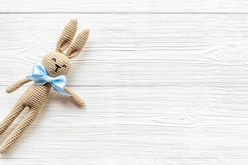 Knitted baby toy rabbit for newborn - background for baby shower