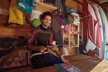 European surfer use digital tablet in wooden hut