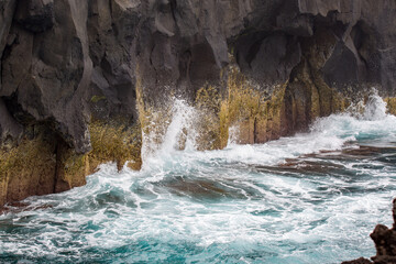 Sea crashing into rocks. Scene from a vulcanic landscape in the Azores
