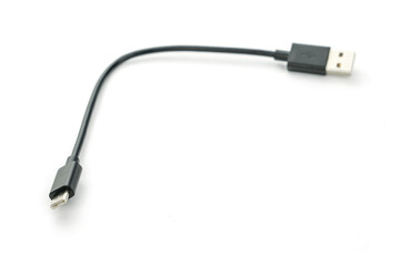 Black USB cable with plugs type A and type C at edges on white background. Soft selective focus. For Mobile charger and Transfer data