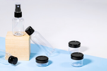 Plastic clear travelling bottles for Cosmetic on wooden podium: soap, gel, lotion, cream, shampoo, make up and liquids. Modern Traveling Concept. Copy Space. Container for carryon.