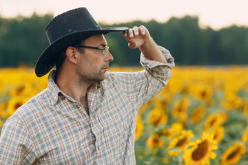 Man farmer standing in a sunflower field