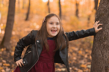 Autumn emotional portrait of laughing child walking in park or forest