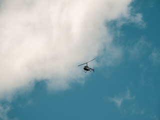 Fototapeta na wymiar Small helicopter in a cloudy sky.