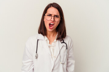 Young doctor caucasian woman isolated on white background screaming very angry and aggressive.