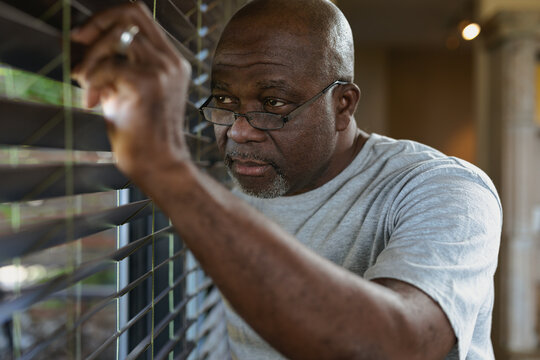 Thoughtful senior african american man looking at the window