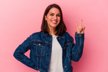 Young caucasian woman isolated on pink background showing number two with fingers.