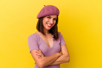 Young caucasian woman isolated on yellow background who feels confident, crossing arms with determination.