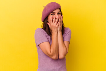Young caucasian woman isolated on yellow background laughing about something, covering mouth with hands.