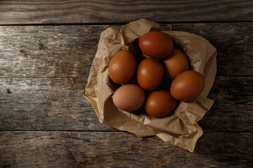 Ecological farm chicken eggs on a rustic wooden table.