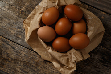 Ecological farm chicken eggs on a rustic wooden table.