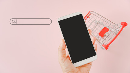 hand holding mobile phone with clipping path on touchscreen ,search bar and blurred shopping cart...