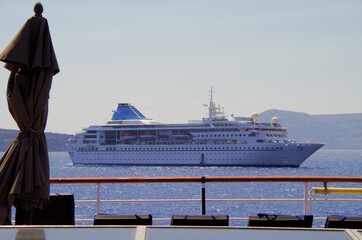 Modern white cruiseship cruise ship liner anchoring in Santorini, Greece during summer...
