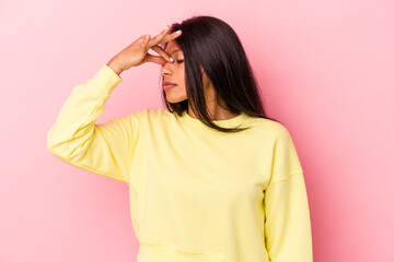 Young latin woman isolated on pink background having a head ache, touching front of the face.