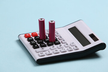Calculator with aa batteries on blue background.