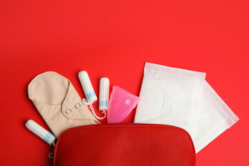 Tampons and other menstrual hygienic products on red background, flat lay