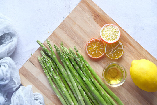 Asparagus Green , Lemon And Oil On A Chopping Board , Top View 