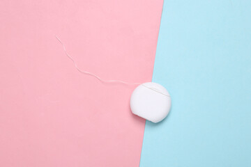 Dental floss on a blue pink pastel background. Top view. Minimalism