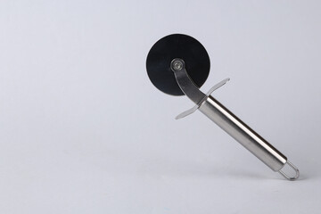 Steel round knife for cutting pizza on gray background