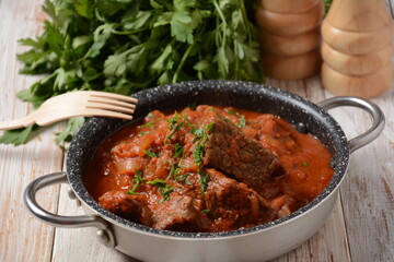 Beef meat stew. Overhead view braised beef meat stew in tomato sauce with herbs