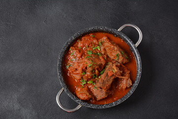 Beef meat stew. Overhead view braised beef meat stew in tomato sauce with herbs