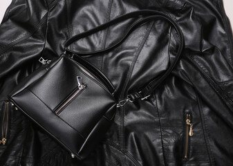 Black leather bag on a leather jacket