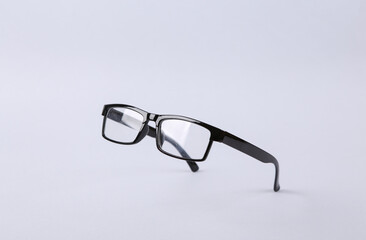 Levitating eye glasses on gray background