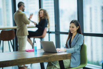 young asian women using computer laptop for online business meeting, modern lifestyle concept, beautiful long black hair lady wearing grey suit outfits, smiling and happy face.