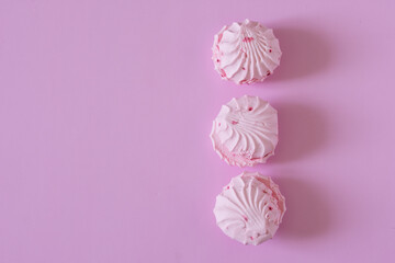 Delicate pink fruit and berry marshmallow lies on a pink background. View from above. Free space for an inscription. Natural lighting in the kitchen