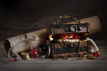pirate treasure: an old wooden chest full of gems, gold coins and expensive jewelry stands on a...