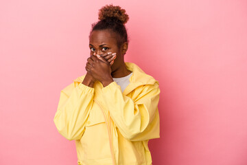 Young african american woman isolated on pink background covering mouth with hands looking worried.