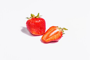 Whole and half ripe strawberry isolated on white background
