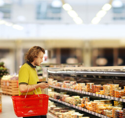 Young man shopping in supermarket, reading product information