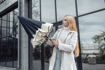 Young fashion woman opens umbrella near the business center