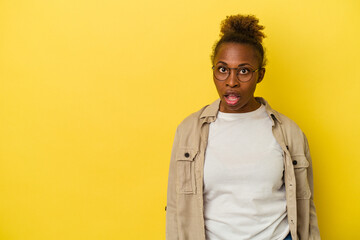 Young african american woman isolated on yellow background being shocked because of something she has seen.