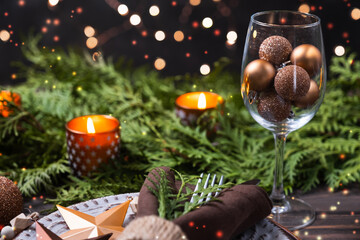 Christmas table setting with decorations, fir branches and candles.