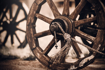 Wooden wheels of an old cart standing in the yard in a village in the countryside in the evening....