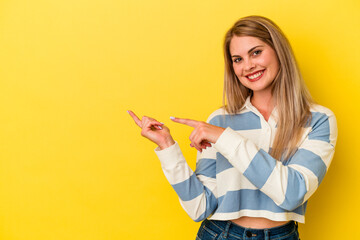 Young russian woman isolated on yellow background excited pointing with forefingers away.