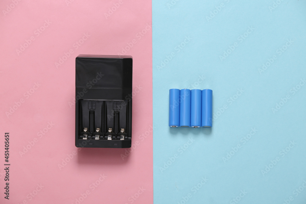 Wall mural battery charger with aa rechargeable batteries on blue pink pastel background