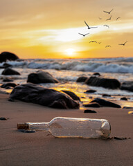 Flasche am Strand im Sonnenuntergang