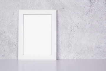 Mockup white frame vertical on table top and wall at home, mock up poster for presentation on desk, your design for gallery photo and picture image, border template and decoration for advertising.