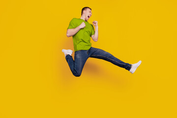 Fototapeta na wymiar Full size profile side photo of young guy angry mad crazy fight conflict kick isolated over yellow background