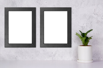 Mockup black frame vertical on the wall and plants in pot on table top at home, mock up poster for...