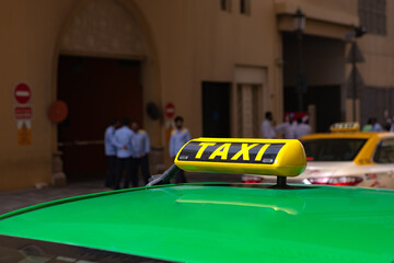 Taxi sign on the roof of a car in a street