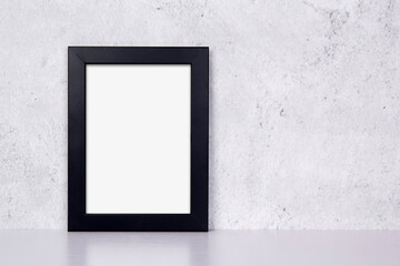 Mockup black frame vertical on table top and wall at home, mock up poster for presentation on desk, your design for gallery photo and picture image, border template and decoration for advertising.