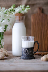 Woman hands holding jar of milk. Pouring milk in glass of milk. Homemade almond cookies with copy space for text .Crispy cookie. Food concept. Selective focus. Vintage style
