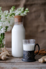 Woman hands holding jar of milk. Pouring milk in glass of milk. Homemade almond cookies with copy space for text .Crispy cookie. Food concept. Selective focus. Vintage style
