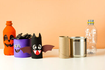Reuse concept art from tin can, toilet tube, plastic bottle. Eco craft ideas. Handmade decor monster, bat and pumpkin