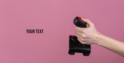 Hands holding retro joystick on pink background. Old gaming. 80s retro wave. Copy space