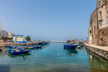 Port w Monopoli z tradycyjnymi niebieskimi łodziami rybackimi, Puglia, Włochy